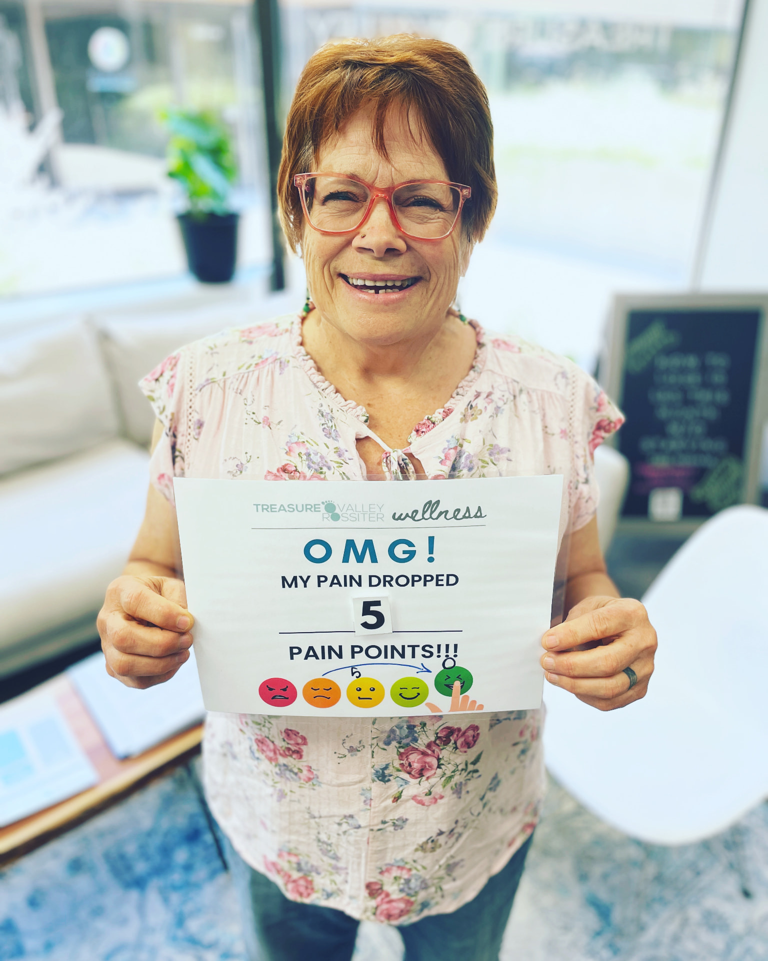 Real Treasure Valley Rossiter client holding a sign showing how much their discomfort dropped after a session (2 of 7)