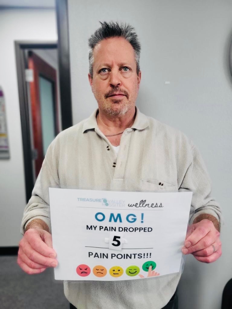 Real Treasure Valley Rossiter client holding a sign showing how much their discomfort dropped after a session (7 of 7)